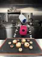 Léo, robot humanoïde Unitree G1 de Libella Robotics, habillé en chef dans une cuisine professionnelle devant des pâtisseries.