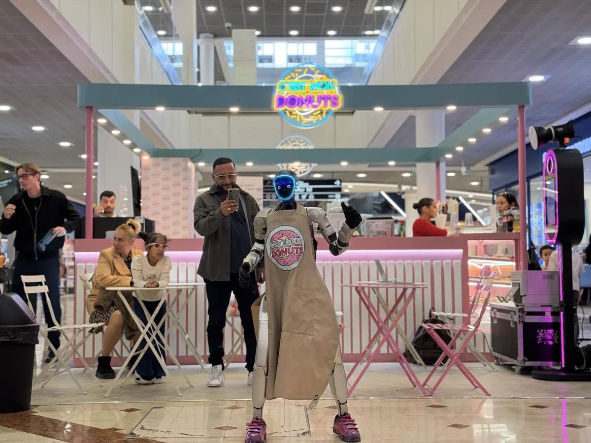 LeoBot danse devant le stand C'est Mon Donuts pendant qu'un visiteur le filme avec son téléphone