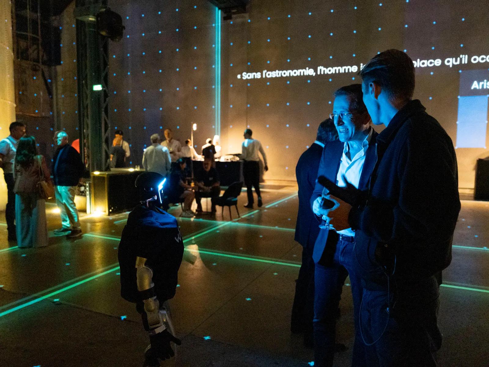 Robot humanoïde Unitree G1 se déplaçant dans la salle pendant une soirée d'entreprise à l'Atelier des Lumières