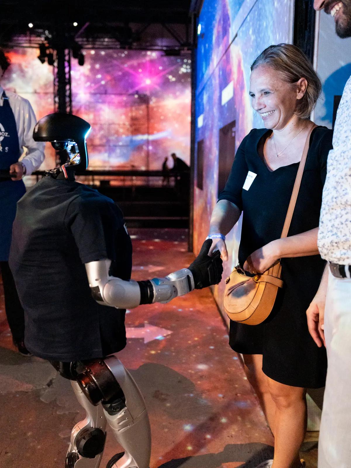 Une invitée danse avec le robot humanoïde Unitree G1 lors d'une soirée d'entreprise à Paris